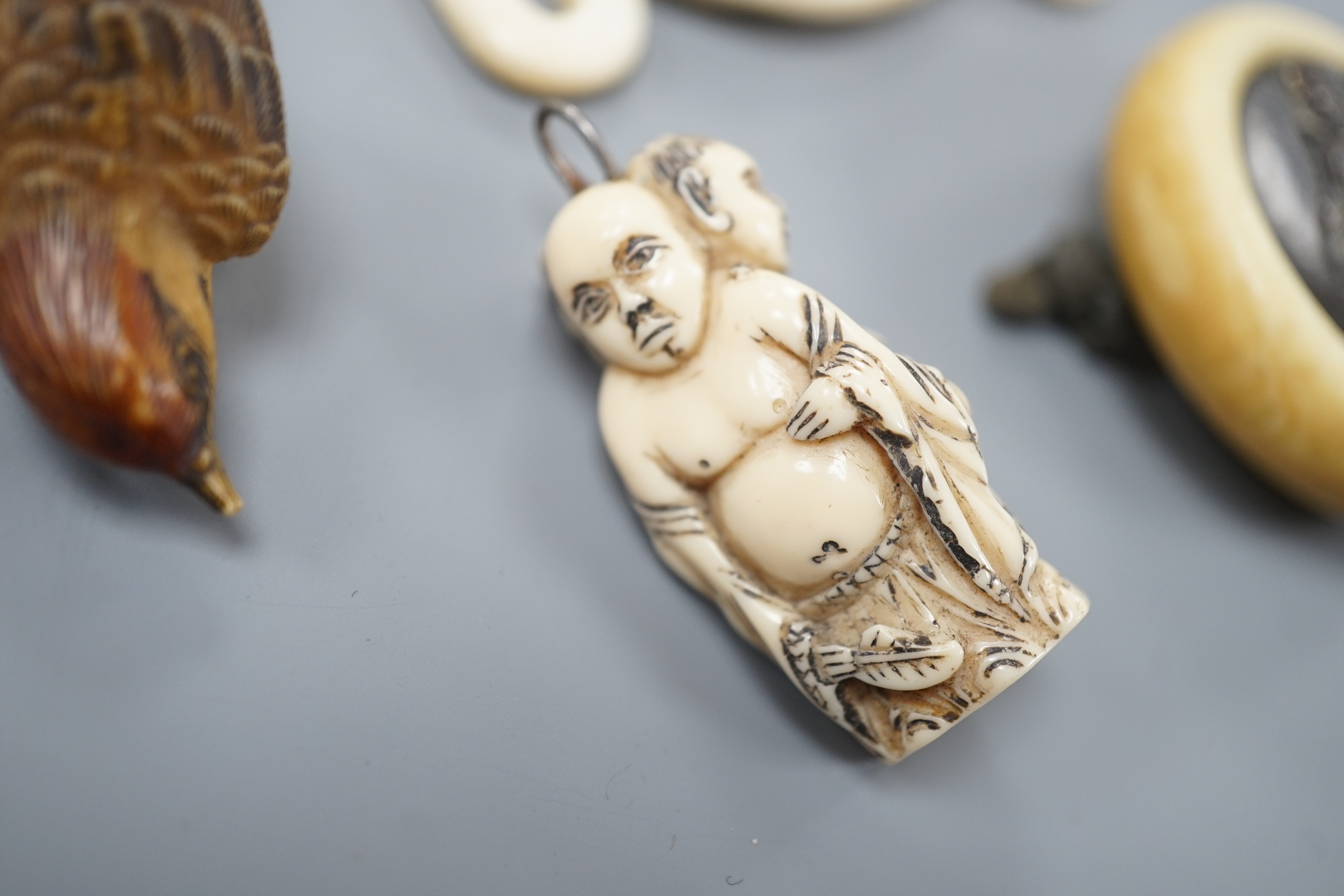 Two Japanese lacquer boxes, an ivory and bronze manju, an ivory ‘lion’ two-piece belt buckle and two simulated ivory items, late 19th/early 20th century, largest Box 11.5 cm